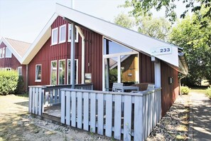 Un edificio rosso con un portico bianco e un cartello con il numero 233.