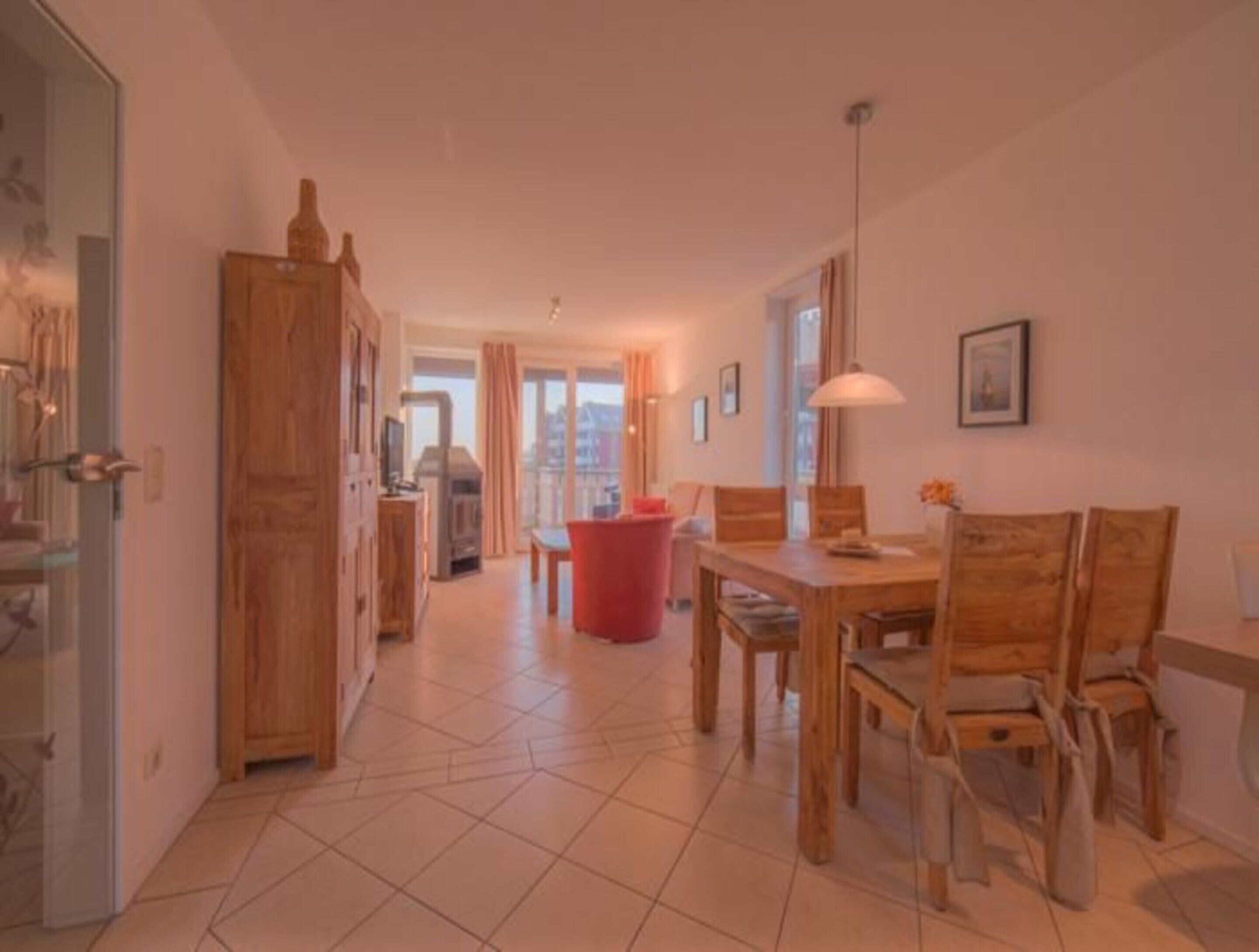 Un grand espace de vie comprenant une table à manger, des chaises, une poubelle rouge et une cheminée.