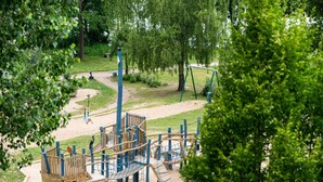 A playground with climbing structures, a slide, and a rope bridge. - Gemutliches Appartement mit Skandinavischem Flair (Mirow)