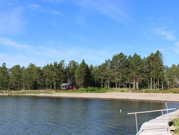 A lakeside property with a dock, surrounded by dense forest and a small cabin. - 6 Person Holiday Home in Bergsjo (Bergsjo)