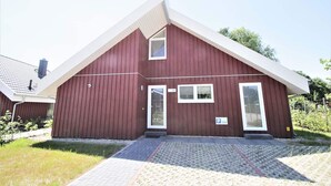 A red building with a white roof, a small window, and a door. - Exklusives Skandinavisches Ferienhaus (Mirow)