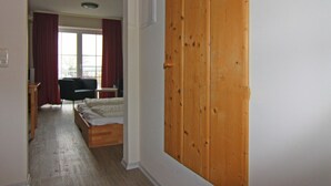 Ein Schlafzimmer mit einem Holfischschrank, einem Bett, einem Schreibtisch und einem Stuhl.