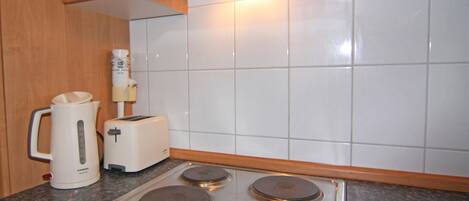 Et køkken med en Siemens kaffemaskine, en brødrister og en komfur i rustfrit stål.