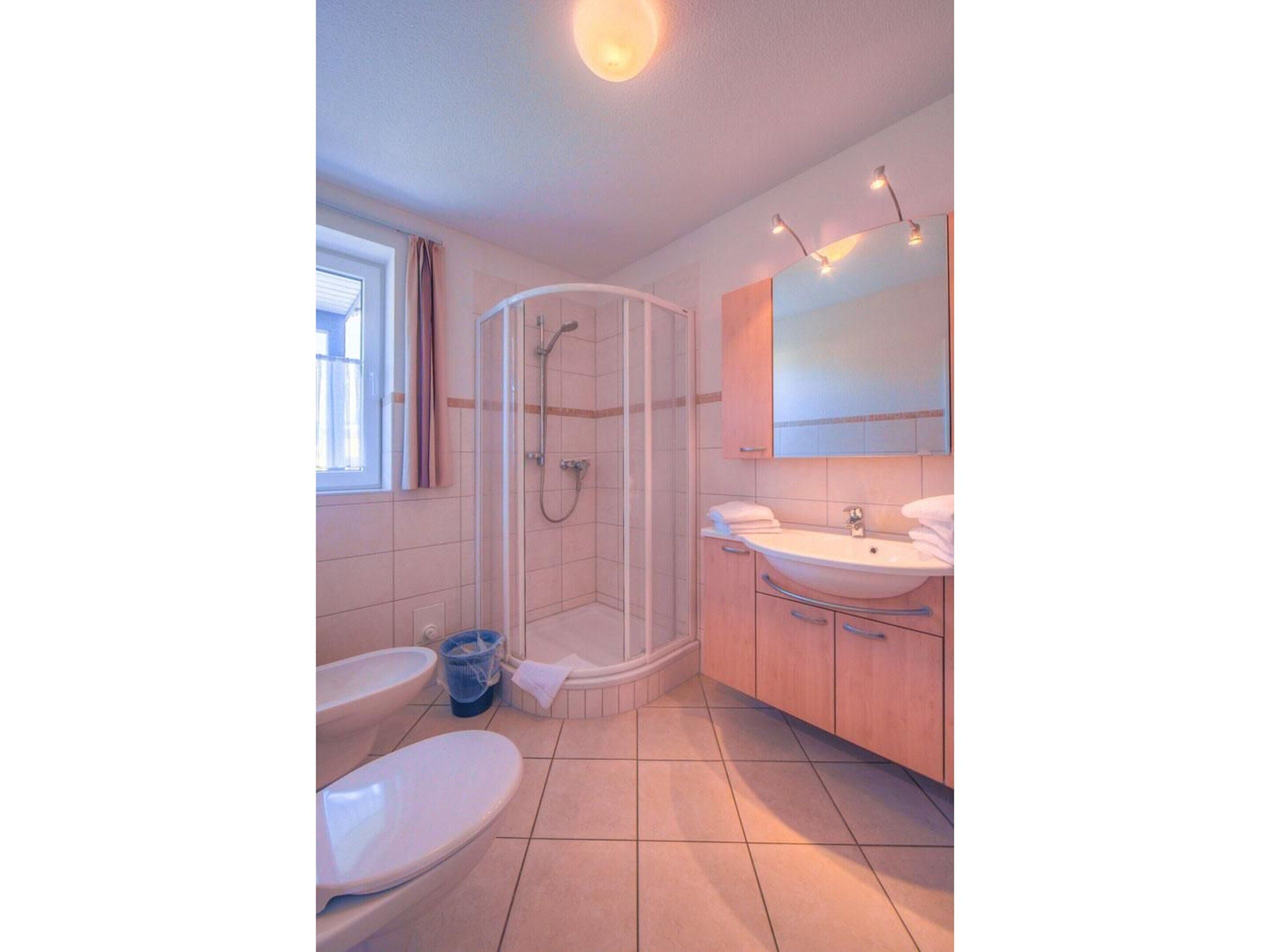 A bathroom with a shower, toilet, and sink.