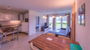 Una cocina moderna con comedor, televisor y vistas al exterior.