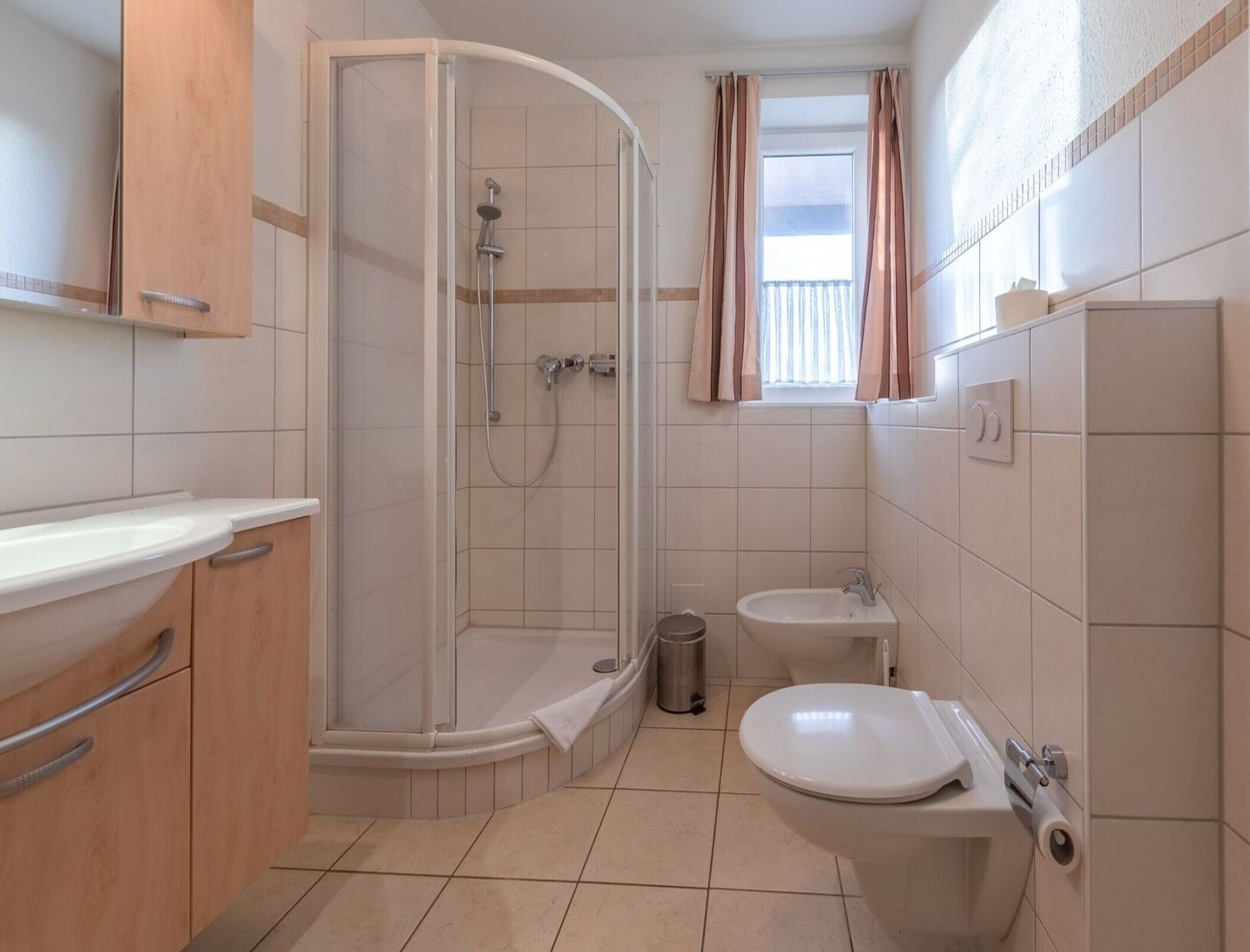 A bathroom with a shower, toilet, and sink.