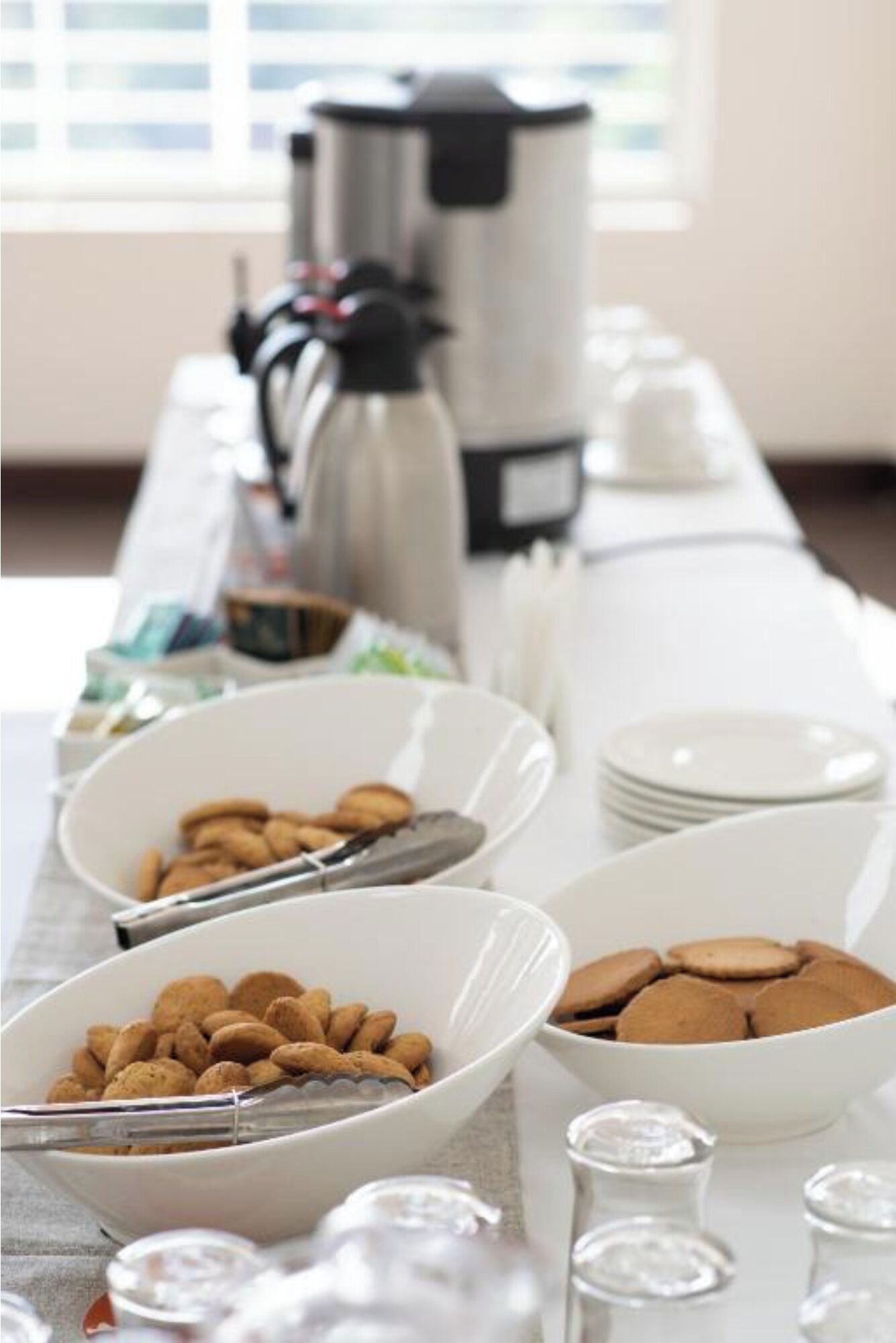 A buffet table with various food items and serving utensils.