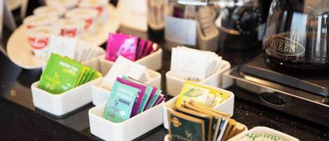 A coffee station with various tea and coffee products, including branded boxes and a coffee maker.