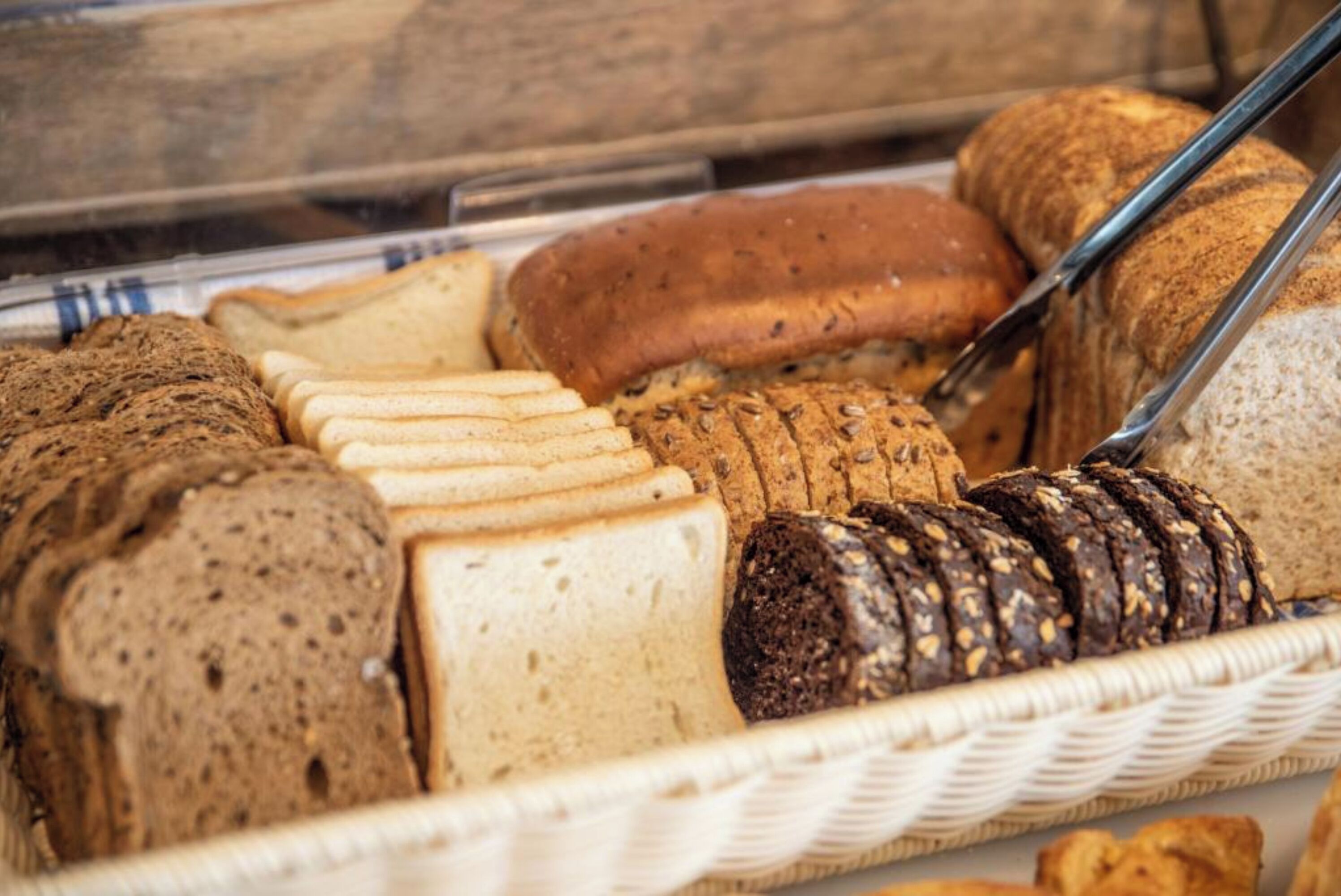 Une variété de pains et de viennoiseries présentés dans un panier.