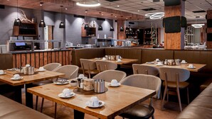 A modern restaurant with wooden tables and booths, a bar area, and pendant lighting. - Appartement im Panoramic Hotel Bad Lauterberg (Bad Lauterberg)