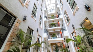 Un atrio de varios niveles con balcones, ventanas amplias y plantas de interior.