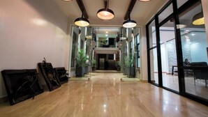 Un hall espacioso con piso pulido, ventanas amplias e iluminación colgante moderna.