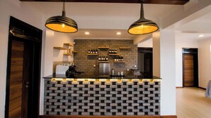 Cocina moderna con salpicadero de ladrillo, dos lámparas colgantes y una estantería para vinos.