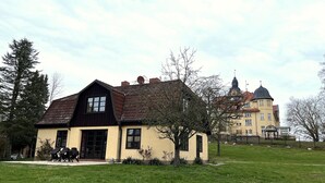 Ein zweistöckiges Haus mit einem geneigten Dach und einer kleinen Veranda.