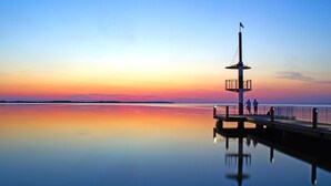 A pier extending into calm waters with a clear sky at sunset. - Tolles Appartment in der Seenplatte (Rechlin)