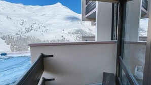 Een balkon met uitzicht op een met sneeuw bedekte berg.