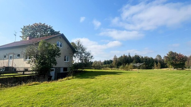 A house with a sloped roof, a small porch, and a large lawn in front. - 4 Person Holiday Home in Tingsryd (Tingsryd)