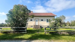 A two-story house with a red-tiled roof, a front door, and a small porch. - 4 Person Holiday Home in Tingsryd (Tingsryd)