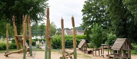 Ein Spielplatz mit Klettergeräten und einer kleinen Holzhütte.