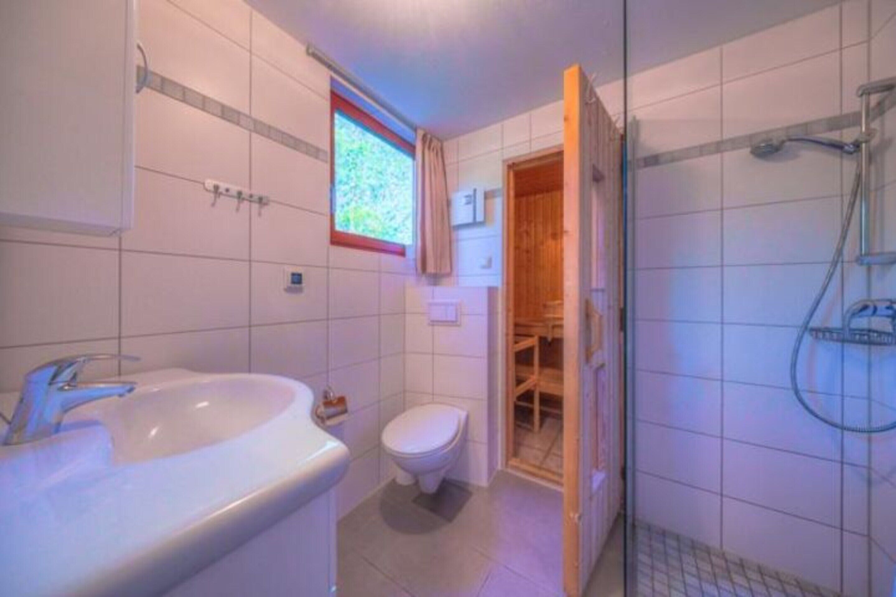 A bathroom with a sink, toilet, and shower area.