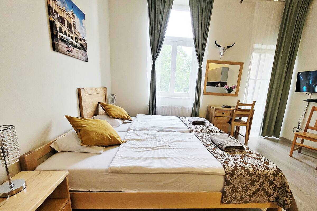 Una camera da letto con un letto di legno, una scrivania, una sedia, uno specchio e un televisore.