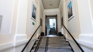 A staircase with black handrails leading to a door at the top. - DReAM Post Aparthotel (Kraków)