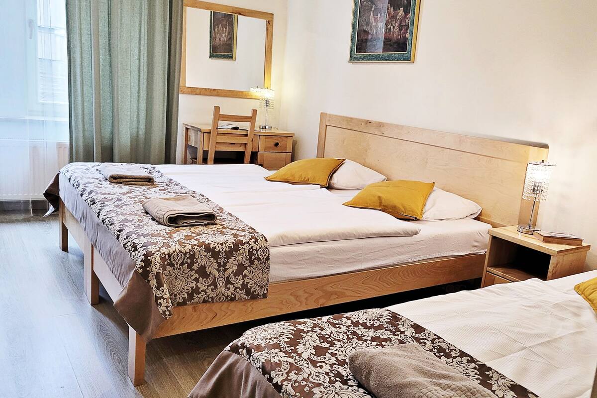Una camera d'albergo con un letto, una scrivania, una sedia, una lampada e un quadro appeso al muro.