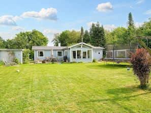 A single-story house with a large front yard, a trampoline, and a covered outdoor seating area. - 10 Person Holiday Home in Graested (Graested)