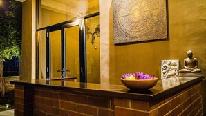 En reception med en murstensdisk, et stort vindue, en vægkunst i form af et kompas og en Buddha-statue.