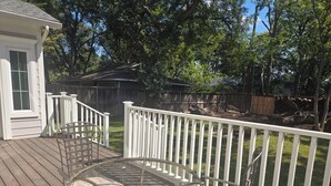 A wooden deck with a glass table and chairs, surrounded by a white fence. - NEW! Gorgeous 4-bedroom in quiet,  upscale  neighborhood near White Rock Lake, (Dallas)
