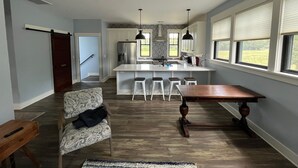 Una cocina amplia con una isla central, taburetes de bar y una mesa de comedor.