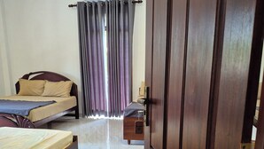 A bedroom with a bed, a wardrobe, and a window with curtains. - Elegant family friendly villa close to airport & beach (Pamunugama)
