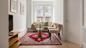 A living room with a sofa, armchairs, a coffee table, and a TV. - Picktheplace Kensington Lux Apartments (London)