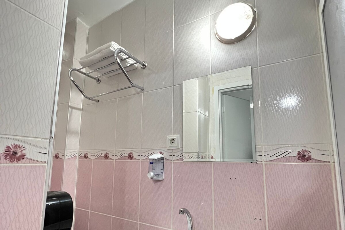 A bathroom with a toilet, sink, and towel rack.