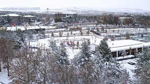A snowy urban landscape with buildings, trees, and a clear sky. - City Blue Hotel (Elazig)