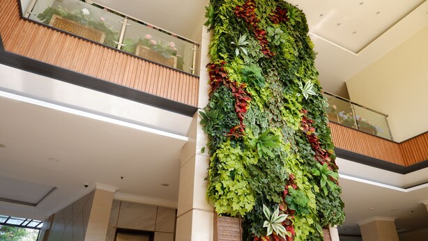 A modern interior with a vertical garden wall, a wooden balcony, and a glass railing. - Point C Hotel (Bandung)