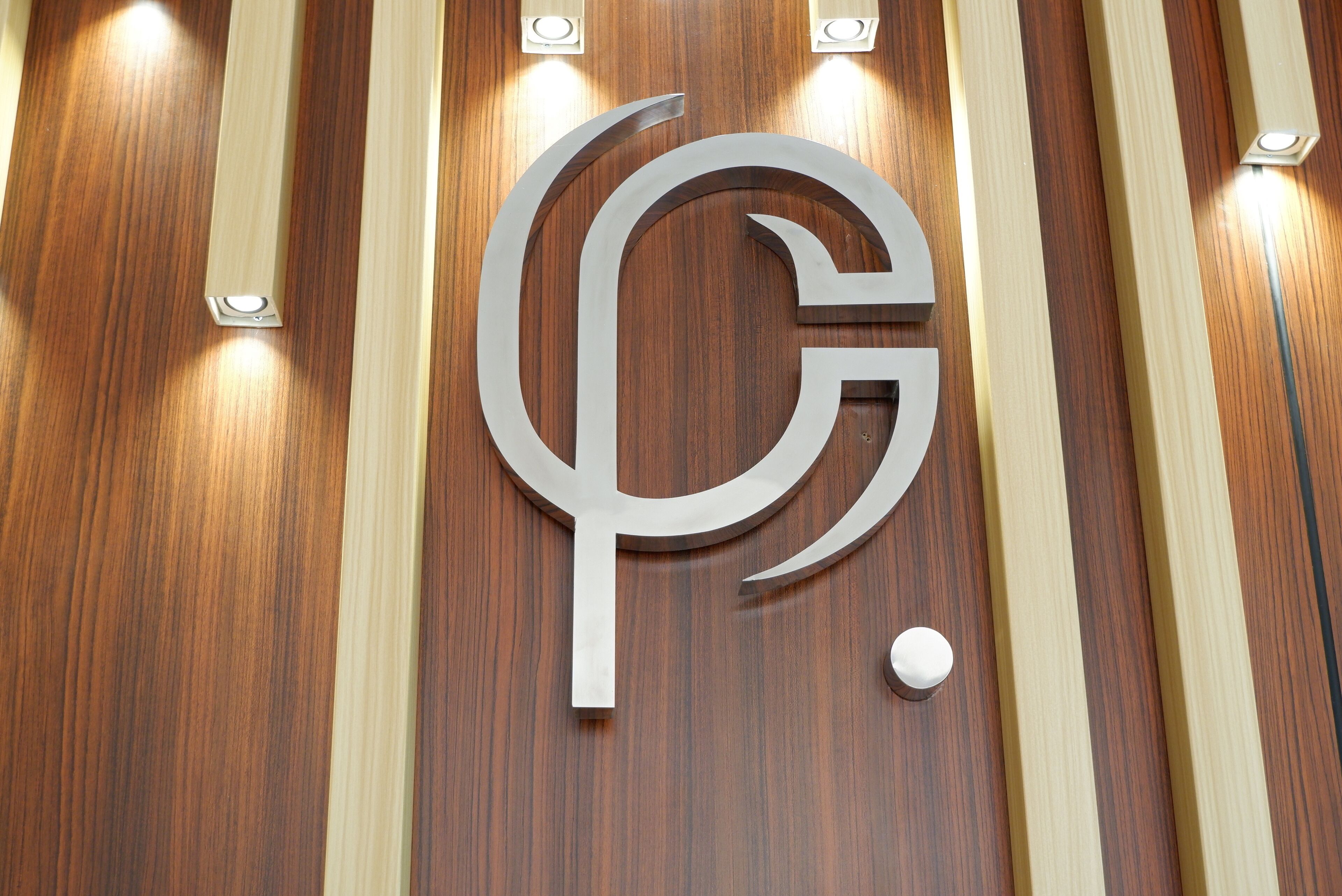 Un muro di legno con un grande logo stilizzato, la lettera 'G'.