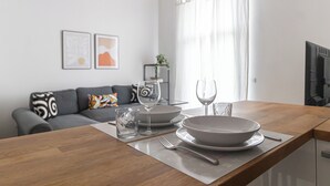A modern kitchen with a wooden countertop, a dining table set with plates, glasses, and cutlery. - Italianway Comfort - Gallura 9 B (Milan)