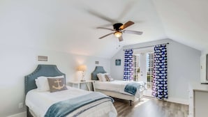 A bedroom with two beds, a ceiling fan, a window with curtains, and a small table with a lamp. - Sel De Vie A 4 Bedrooms Sleeps 10 (Gulf Shores)