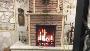 A fireplace with a stone wall and a tiled floor. - Hotel bani (Kutaisi)