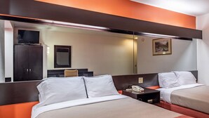 A hotel room with two beds, a large mirror, a television, and a painting on the wall. - Motel 6 Chattanooga, TN - Downtown (Chattanooga)