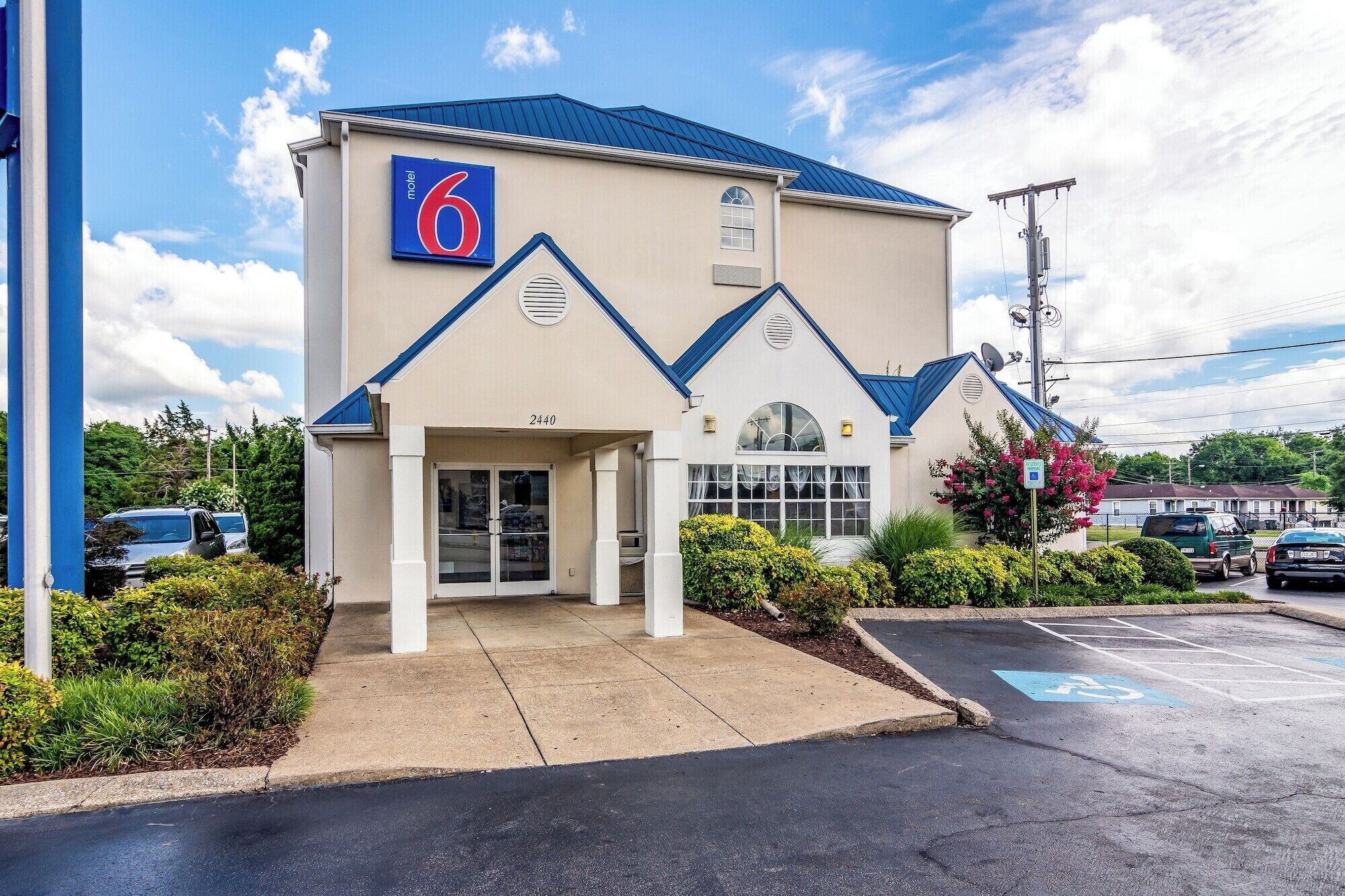 A motel with a '6' sign, a gated entrance, and a parking lot.