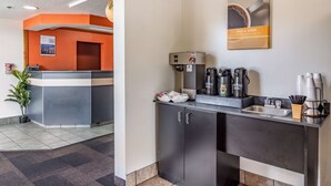 A modern hotel reception area with a grey reception desk, a coffee machine, and a sink. - Motel 6 Chattanooga, TN - Downtown (Chattanooga)