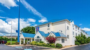 A motel with a large blue sign, a covered waiting area, and a parking lot. - Motel 6 Chattanooga, TN - Downtown (Chattanooga)