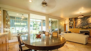 A spacious living area with a large round table, a sofa, and a fireplace. - Family-Friendly Oasis with Pool (Cuernavaca)