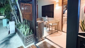 A wooden deck with a sign reading "CASA TURQUEÑA," a covered outdoor seating area with chairs and a table, and a staircase leading to an upper level. - Casa Turquesa (Los Roques)