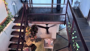 A spacious living area with a staircase, a ceiling fan, and various decorative items including a lighthouse model and a bookshelf. - Casa Turquesa (Los Roques)