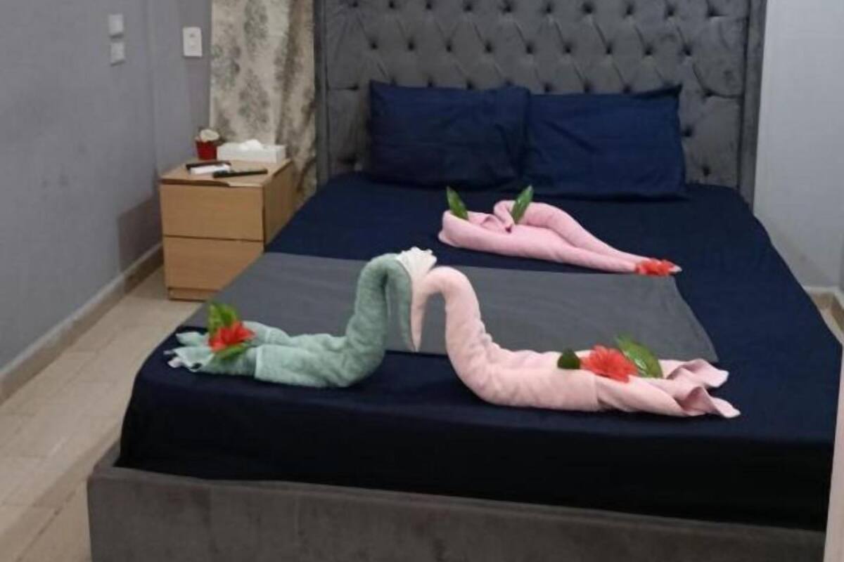 Quarto com uma cama grande, uma mesa de cabeceira e um ar condicionado.