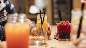 A table with three drinks, one with a lemon slice and black straw, another with a berry garnish and black straw, and a third with a red drink and black straw. - Novotel Hamburg Hafencity (Hamburg)