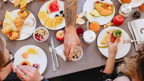 A group of people dining at a table with various fruits, pastries, and beverages. - Novotel Hamburg Hafencity (Hamburg)